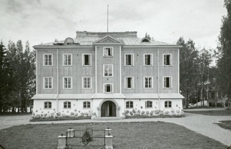 Koulurakennus vuonna 1928. Etualalla näkyy kuningas Haakon VII:n istuttama kuusi. Kuva Museovirasto